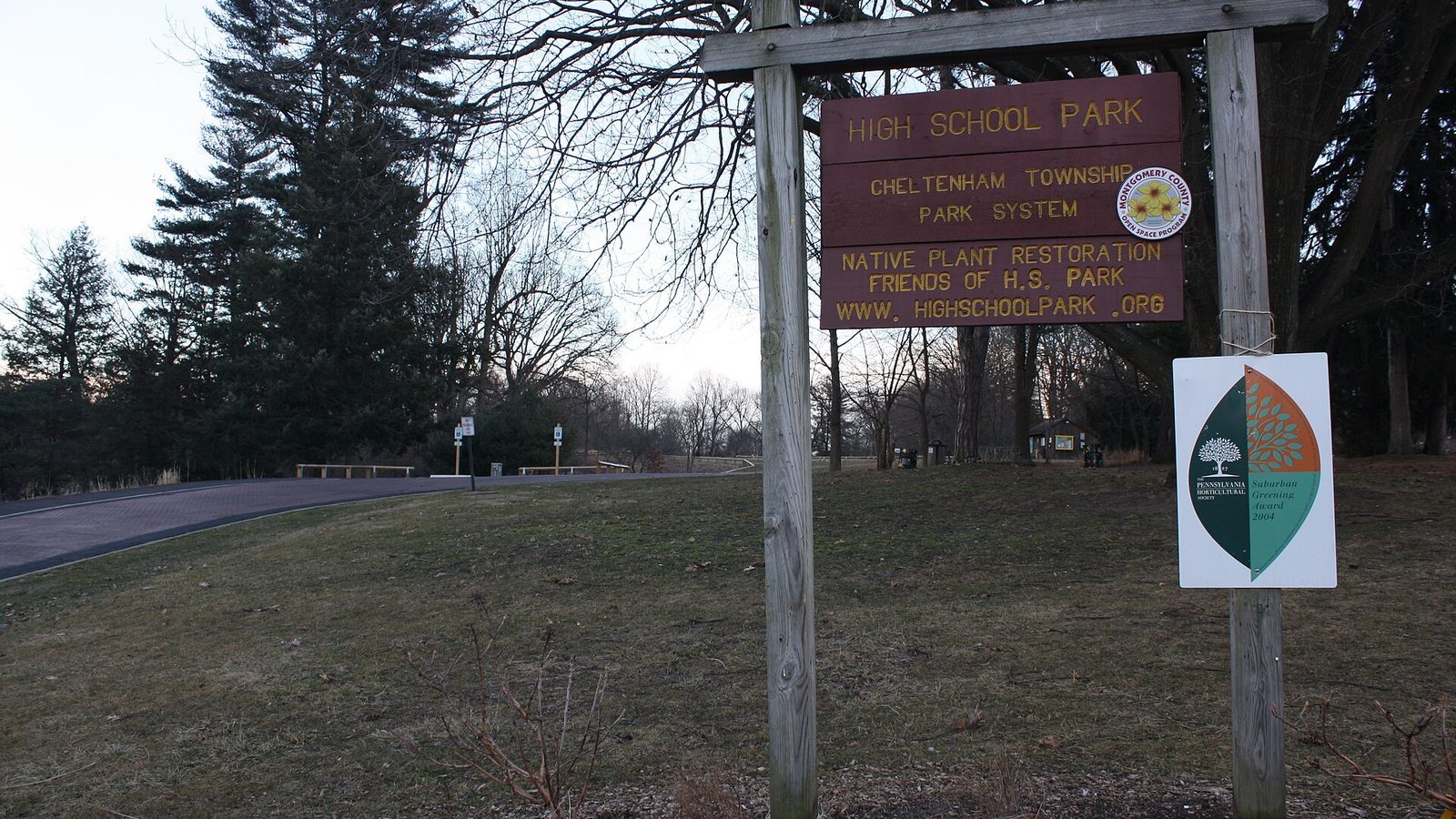 The wooden park sign and open meadow at High School Park in Elkins Park, Pennsylvania