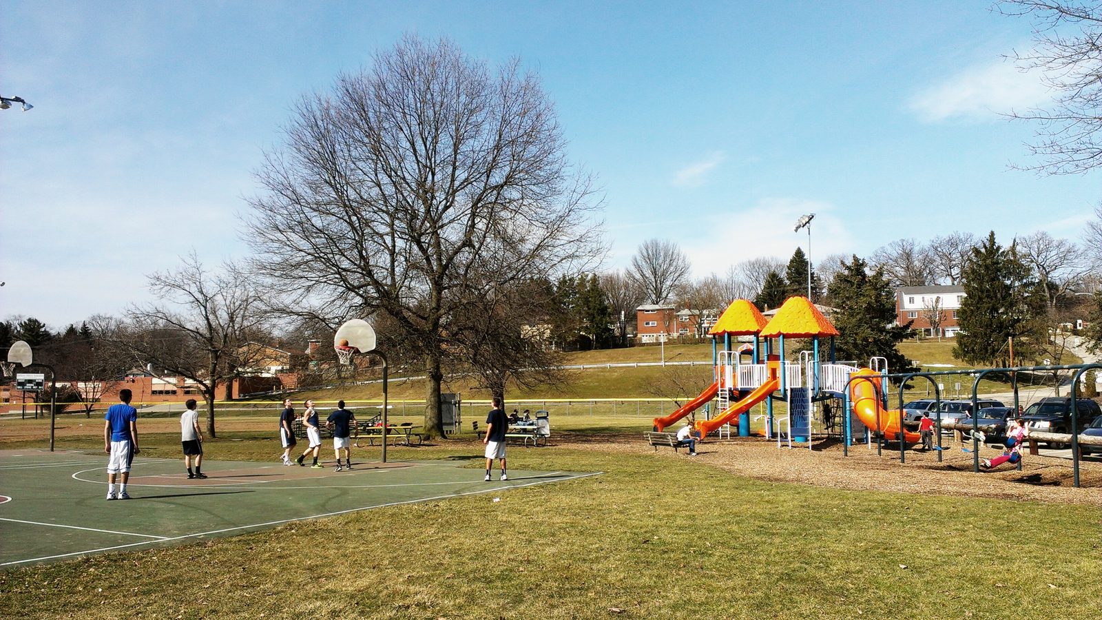 Outdoor basketball courts beside a playground at a Pennsylvania township park, similar to the courts at Harry S. Renninger Recreation Area in Glenside